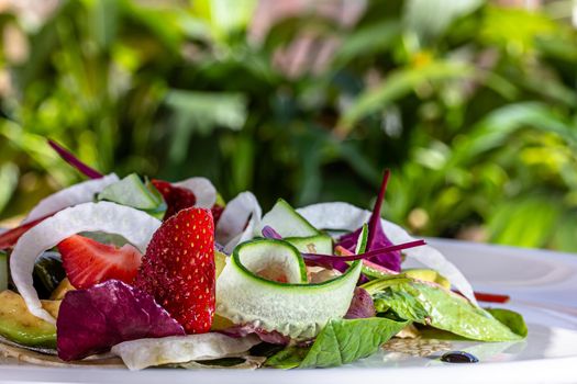 Summer Strawberry, cucumber salad with lettuce, feta cheese and almonds. Healthy Food.