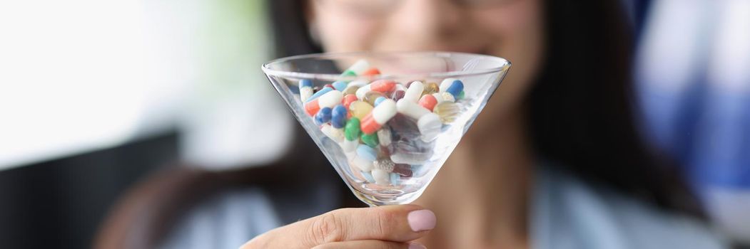 Close-up of glass filled with medication, dietary supplement vitamin, multivitamins. Bunch of pills, recovery treatment, doctors prescription. Healthcare, sedation meds concept. Blurred background