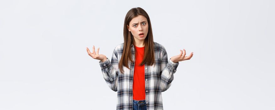Lifestyle, different emotions, leisure activities concept. Frustrated and confused young woman asking for answers, shrugging with hands spread sideways, stare camera bothered with strange situation.