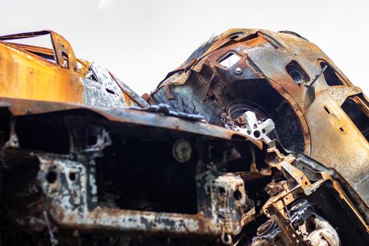 Broken and burned cars in the parking lot, accident or deliberate vandalism. Burnt car. Consequences of a car accident. Damaged by arson. Dump of civilian vehicles shot by Russian troops in Ukraine