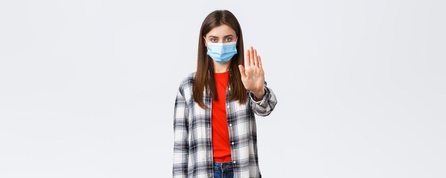 Coronavirus outbreak, leisure on quarantine, social distancing and emotions concept. Stop spreading covid-19 stay home. Serious young woman stretch hand in prohibition, restriction or warning.