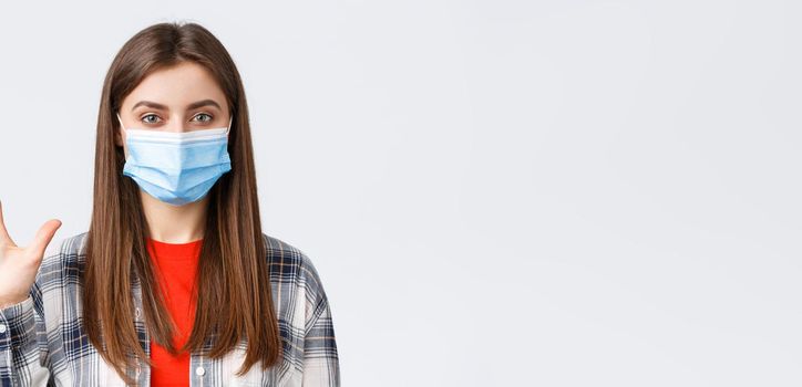 Coronavirus outbreak, leisure on quarantine, social distancing and emotions concept. Attractive female in medical mask and casual clothes show five fingers, number of order, white background.