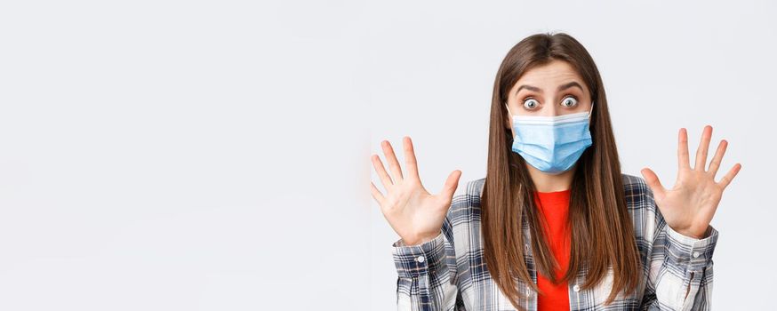 Coronavirus outbreak, leisure on quarantine, social distancing and emotions concept. Excited young attractive woman in medical mask show ten fingers, number or amount, stare impressed.