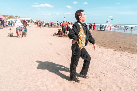 Latin man dressed in Caribbean costume in profile on the beach. Photo with copy space