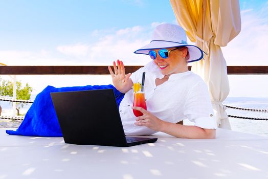 businesswoman handle buisness on her trip by laptop at summer vacation. freelancer at vacation hollyday with laptop