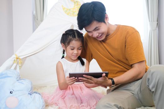 Asian father is helping and support daughter to studying the lesson of online class.