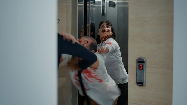 Businessman leaving office but starting to run when creepy brain-eating zombies come out of elevator. Man going home but horror looking bloody monsters get in his way and chase him downstairs.