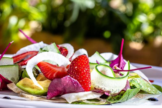 Summer Strawberry, cucumber salad with lettuce, feta cheese and almonds. Healthy Food.