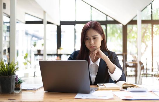 Asian woman working laptop. Business woman busy working on laptop computer at office..