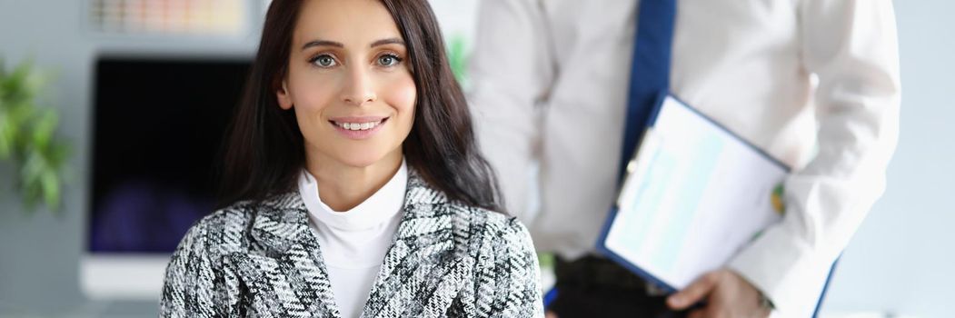 Portrait of successful businesswoman with crossed arms in office with colleague. Coworkers on working place in company, corporate meeting. Career concept