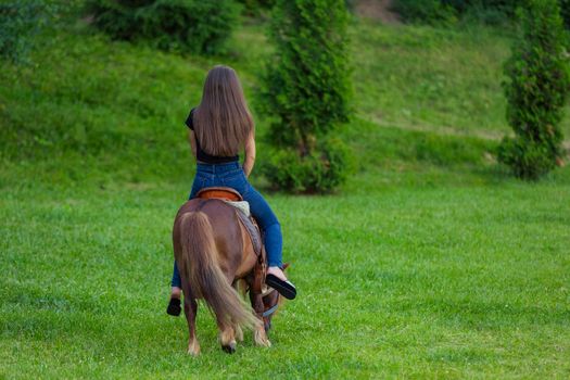 woman riding a pony on the lawn