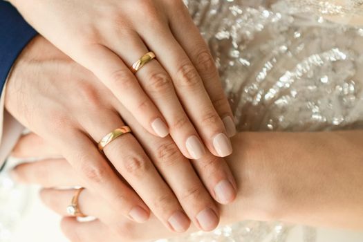 Close up of wedding rings on hands of newlyweds. Hands of the bride and groom