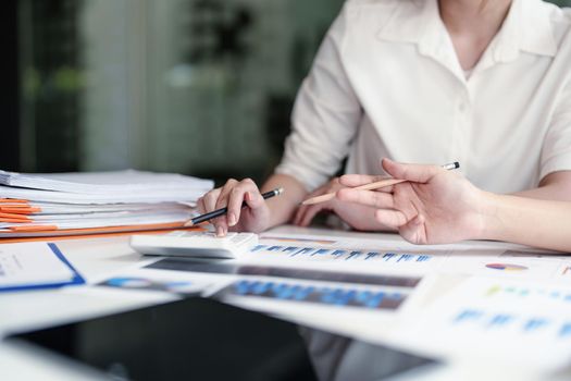 financial, Planning, Marketing and Accounting, Asian young Economist using calculator to calculate investment documents with partners on profit taking to compete with other companies.