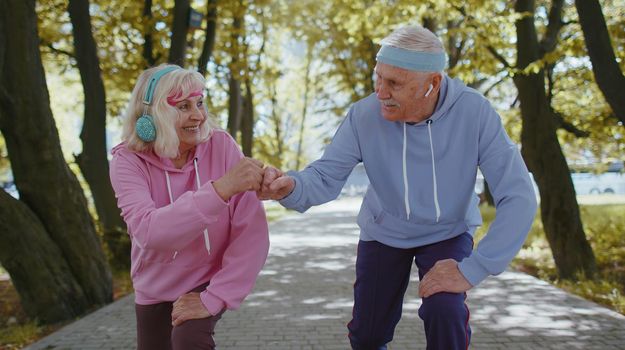 Athletic fitness senior elderly sport jogger man, woman training running cardio workout in summer park at morning. Old grandparents starting run race together. Active retired mature people motivation