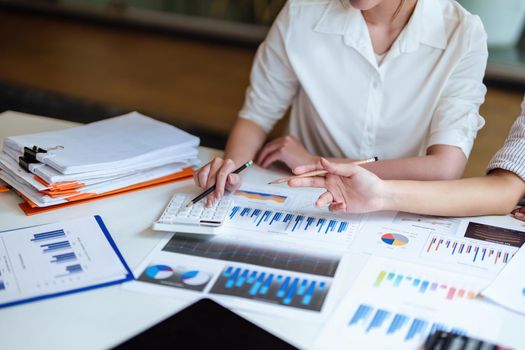 financial, Planning, Marketing and Accounting, Asian young Economist using calculator to calculate investment documents with partners on profit taking to compete with other companies.