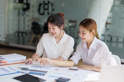 financial, Planning, Marketing and Accounting, Asian young Economist using calculator to calculate investment documents with partners on profit taking to compete with other companies.