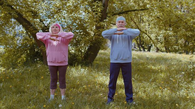 Athletic fitness senior elderly sport man woman training cardio workout sretching in summer park at morning. Old grandparents enjoying working out healthy lifestyle. Active retired people motivation