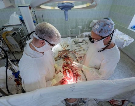 open heart surgery, surgeon, hands, instruments, blood.