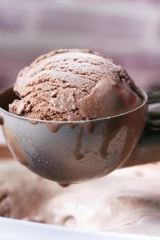 hand picking ice cream with a spoon from a bowl .