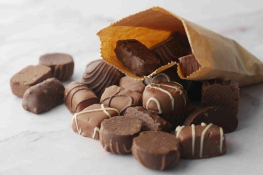 dark chocolate spilling from a paper packet .