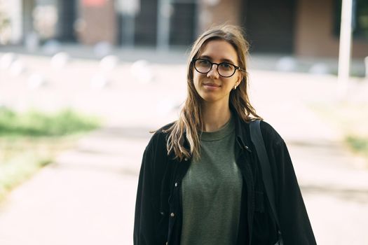 Portrait of a smiling young girl with glasses in the park. High-quality photo