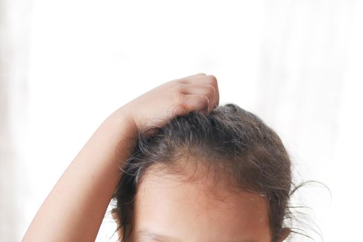 child Scratching Head Against white background