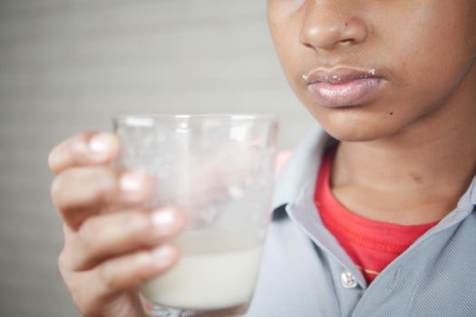 teenage boy drinking milk while sited .