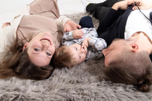 Young caucasian happy family having fun on floor in living room at home.