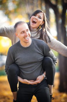 Young happy couple in love fooling around outdoor.