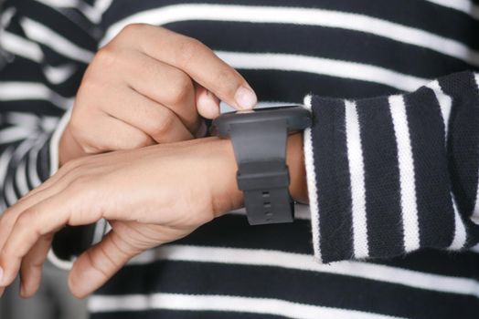 man's hand using smart watch
