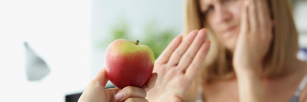 Portrait of person give apple to friend and woman refuse to eat because of tooth pain. Hold hand near face. Dental problem, healthcare, toothache concept