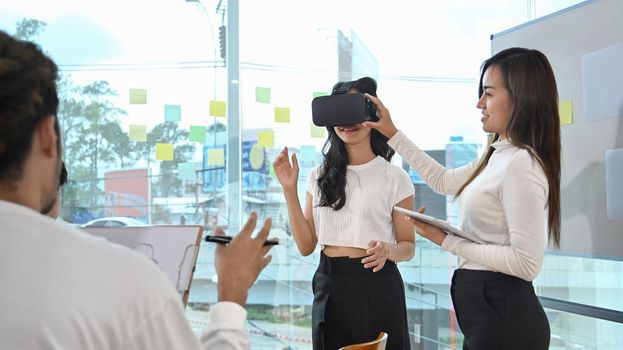 Team of developers wearing virtual reality glasses working with new project or program during a business meeting.