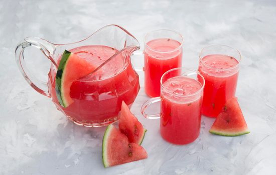 fresh red watermelon drink on hot summer day on light gray cement background. High quality photo
