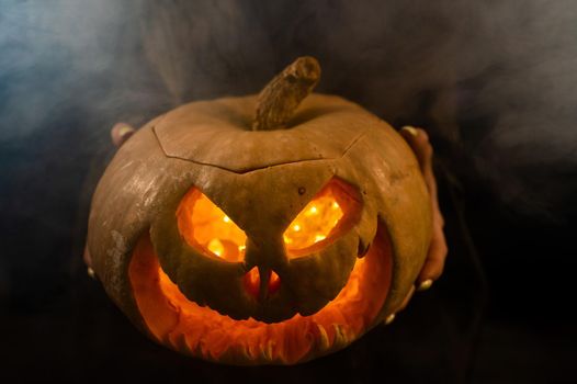 The witch is holding a pumpkin jack about a lantern glowing in the dark. Halloween