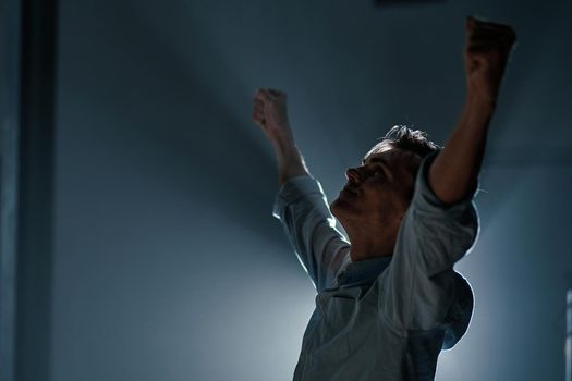 close-up. tired young businessman stretching during night work. side view.