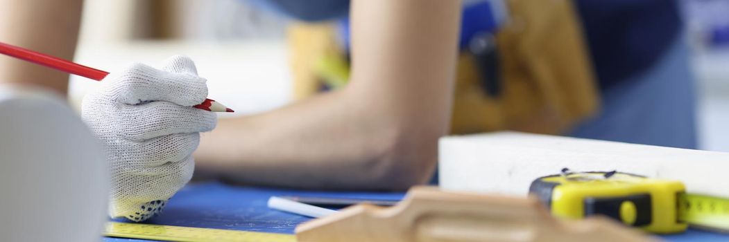 Close-up of woman worker making corrections in construction planning with pencil. Qualified forewoman and blueprint on workplace. Renovation, build concept