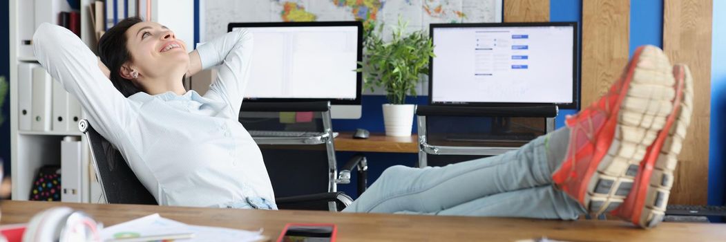 Portrait of female employee chilling and put legs on table after hard day at work. Exhausting and busy day in company, time to rest. Boss, break concept