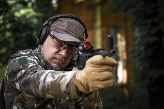 Outdoor shooting range. Police training in shooting gallery with weapon. Shotgun weapon action course. Private military contractor at tactical training course. Shooter with a gun in military uniform.