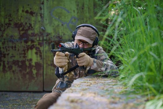 Soldier of special forces combat training. Man in military ammunition stand in guard. Military man hide in position with weapon in hands. Ranger during the military operation.