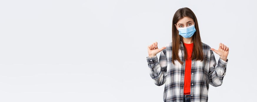 Coronavirus outbreak, leisure on quarantine, social distancing and emotions concept. Confident young woman in medical mask, freelancer pointing herself, show-off or bragging personal achievement.