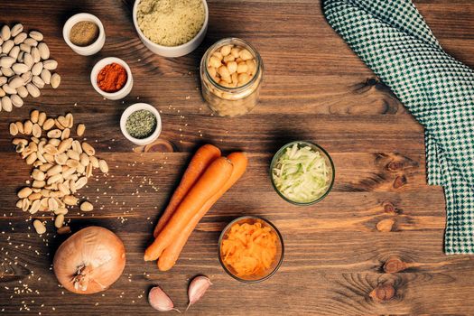 still life with burger ingredients for veggie protein source on wooden background, top view, vegetarian food and healthy lifestyle concept