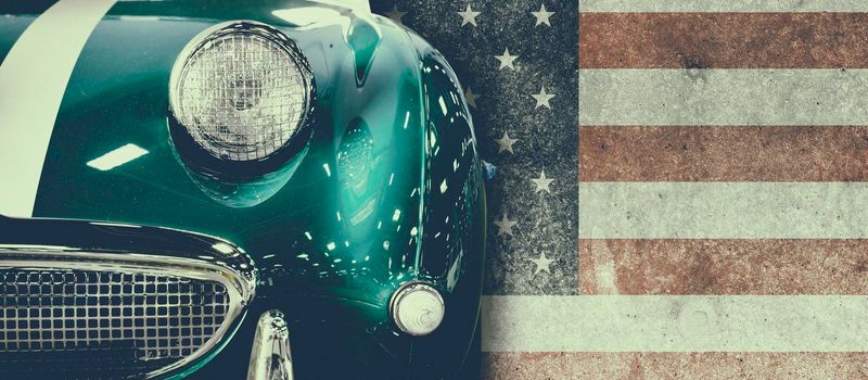 Front view of a vintage car with USA flag in background