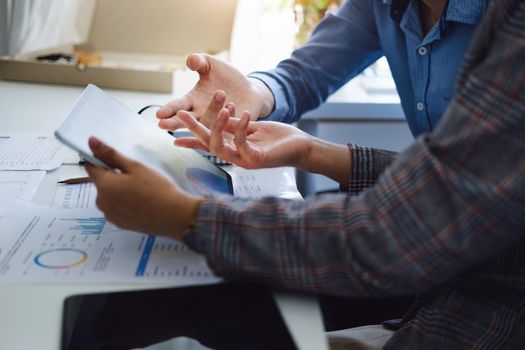 Negotiation, Analysis, Discussion, Asian young economist and marketer using tablet computer to plan investments and financial to prevent risks and losses for the company.