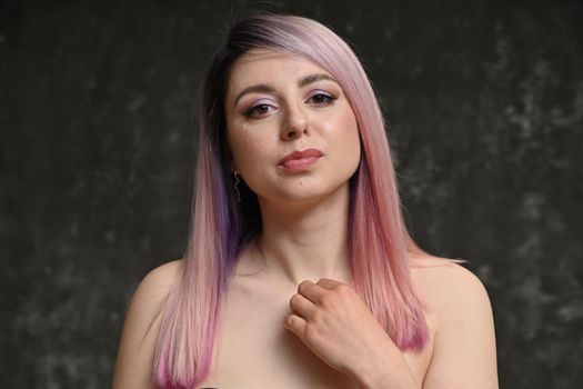 Sensual portrait of a serious girl with pink hair