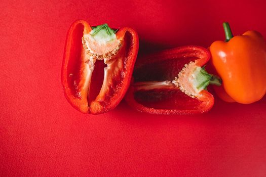 SWEET, fresh RED PEPPER ON A RED BACKGROUND, cut in half. photo for the menu, proper nutrition. fresh vegetables.