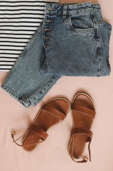 Summer fashion vacation. flat lay composition with female top, denim shorts, sandals top view.
