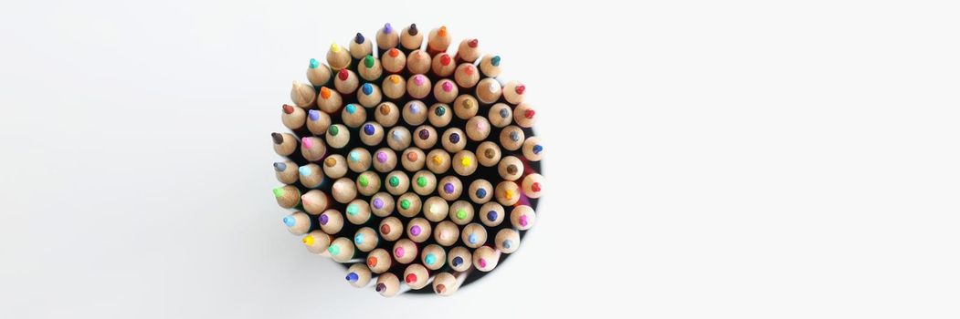Top view of collection of colourful pencils placed in round shaped container. Use them for drawing, neat on white background. Art, perfectionism concept