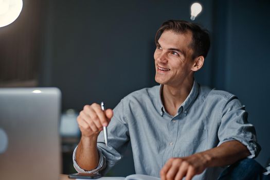 young businessman who came up with an idea. A light bulb is a symbol of an idea above your head