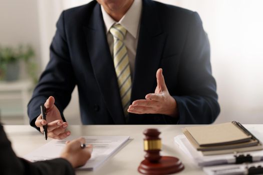 Business woman and lawyers discussing contract papers with brass scale on wooden desk in office. Law, legal services, advice, Justice concept