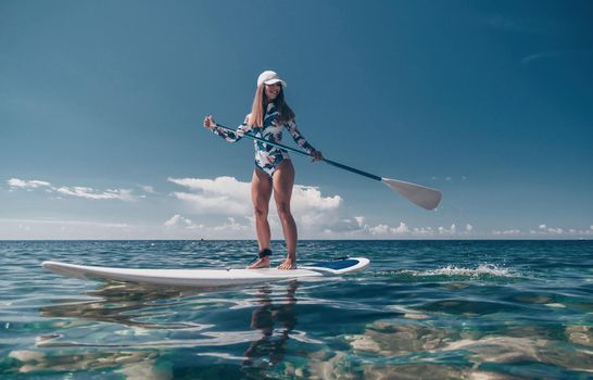 SUP Stand up paddle board. Young woman sailing on beautiful calm sea with crystal clear water. The concept of an summer holidays vacation travel, relax, active and healthy life in harmony with nature